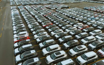 Aerial shot of an extensive car parking lot filled with new vehicles ready for distribution.