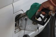 Close-up of a hand refueling a vehicle. E20 petrol pump nozzle in use.